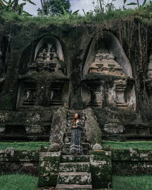 Stone temple facade in Ubud with a visitor standing on the steps