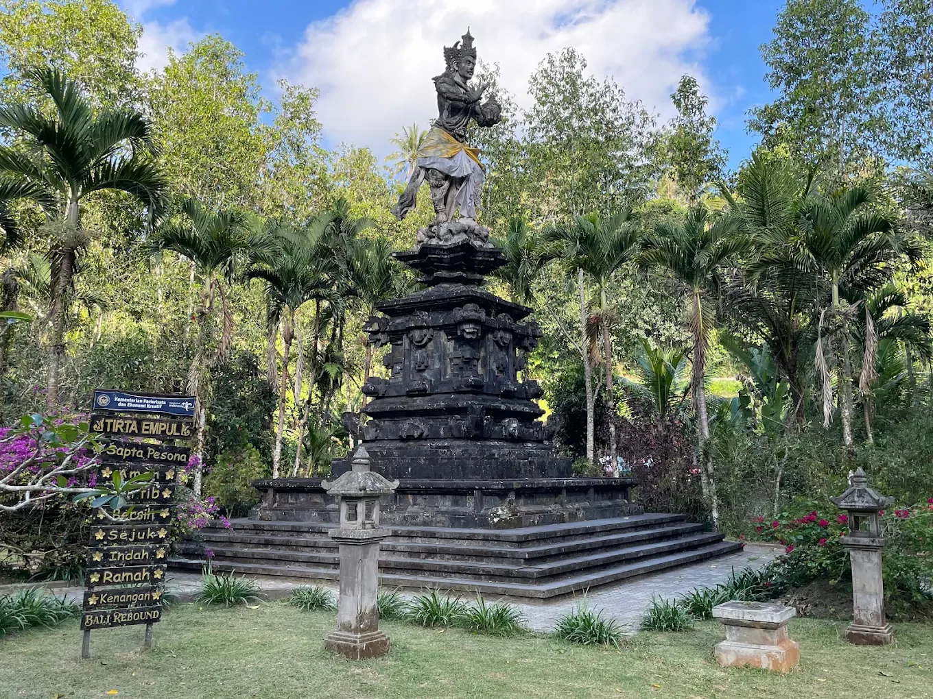 Tirta Empul Temple courtyard statue surrounded by tropical greenery