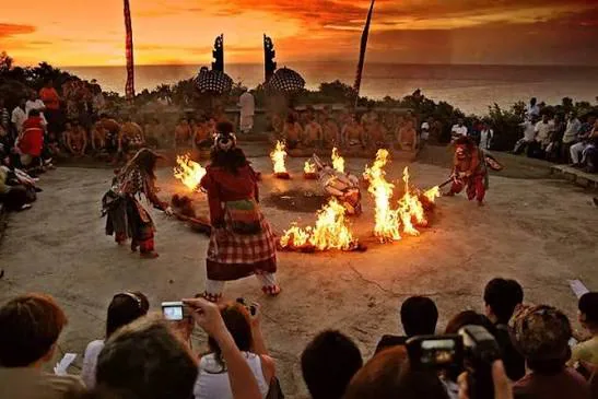 Kecak fire dance performance at Uluwatu with a sunset sky over the ocean