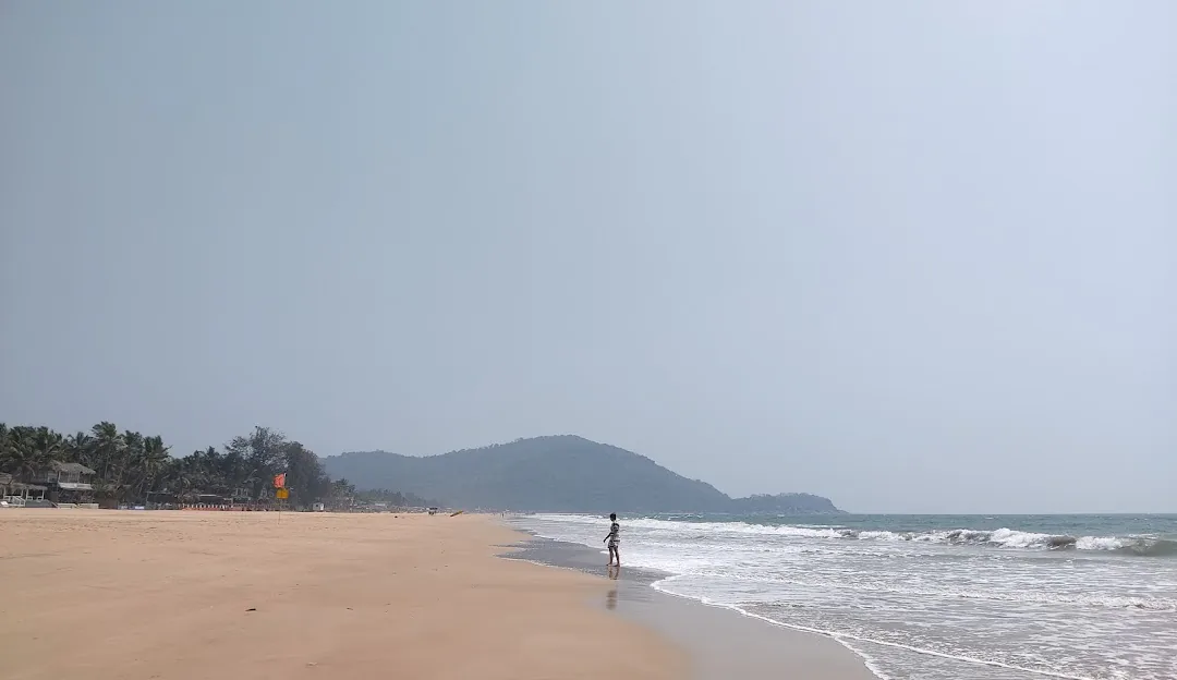 Agonda Beach in South Goa with a broad sandy shoreline, gentle surf and hazy coastal hills