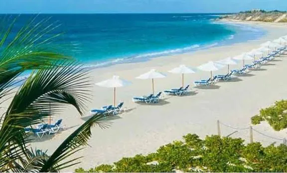 Colva Beach in South Goa with turquoise water, white umbrellas and a long sandy curve