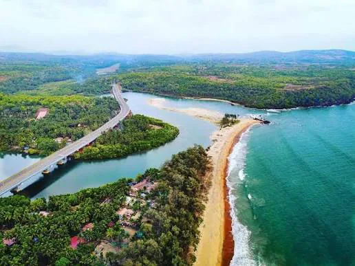 Galgibaga Beach in South Goa with a narrow sandspit, river mouth and green coastal hills