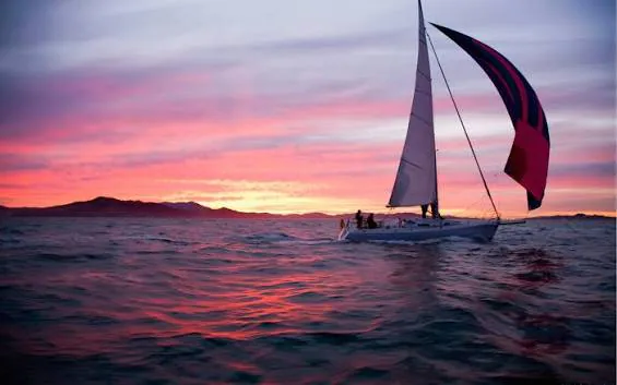 Private sunset sail in Goa with a yacht on the sea at dusk and a pink-orange sky