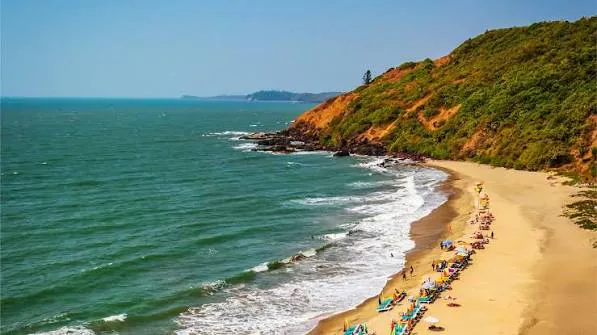 Vagator Beach in North Goa with a curved shoreline, rocky headland and blue-green sea
