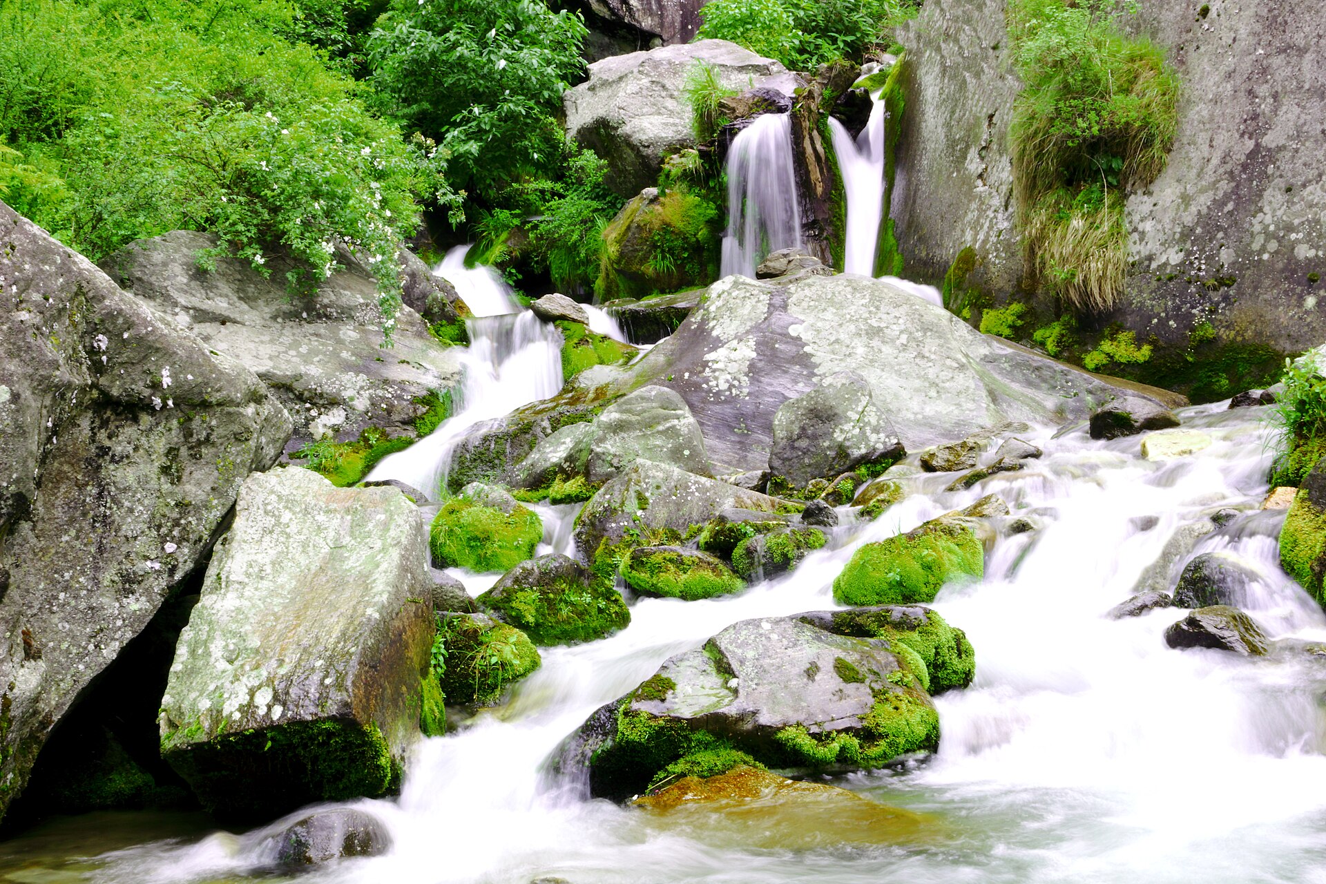 Water flowing over mossy rock at Jogini Falls near Manali