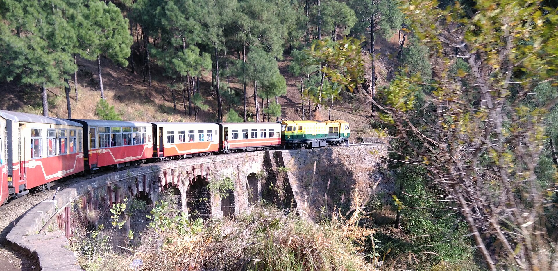 Kalka-Shimla Railway train crossing a stone bridge