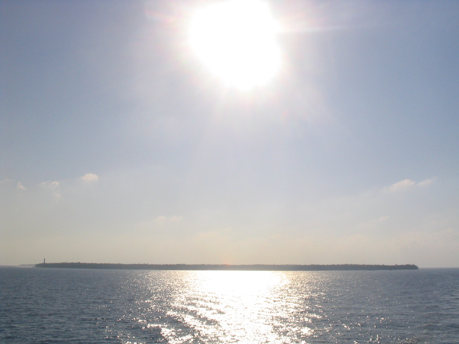 A low sunlit island silhouette above the Arabian Sea in Lakshadweep