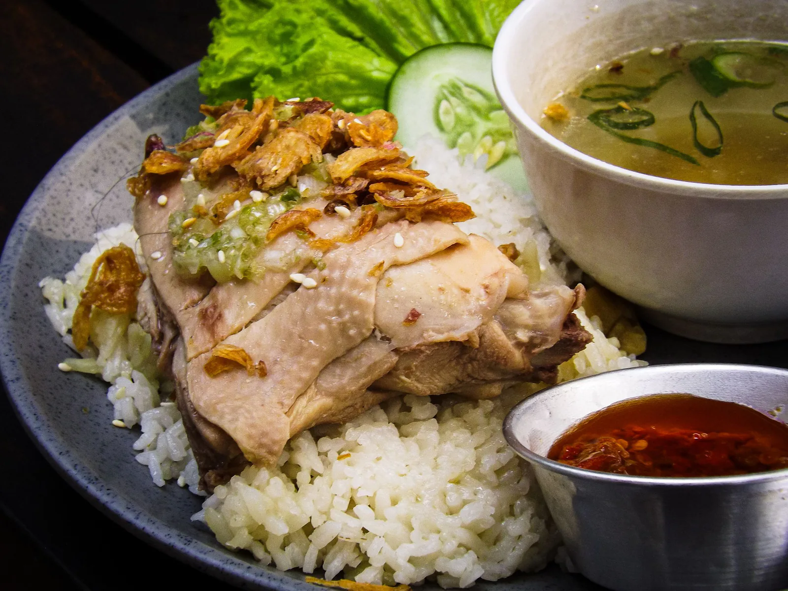 Hainanese chicken rice served with soup and chilli