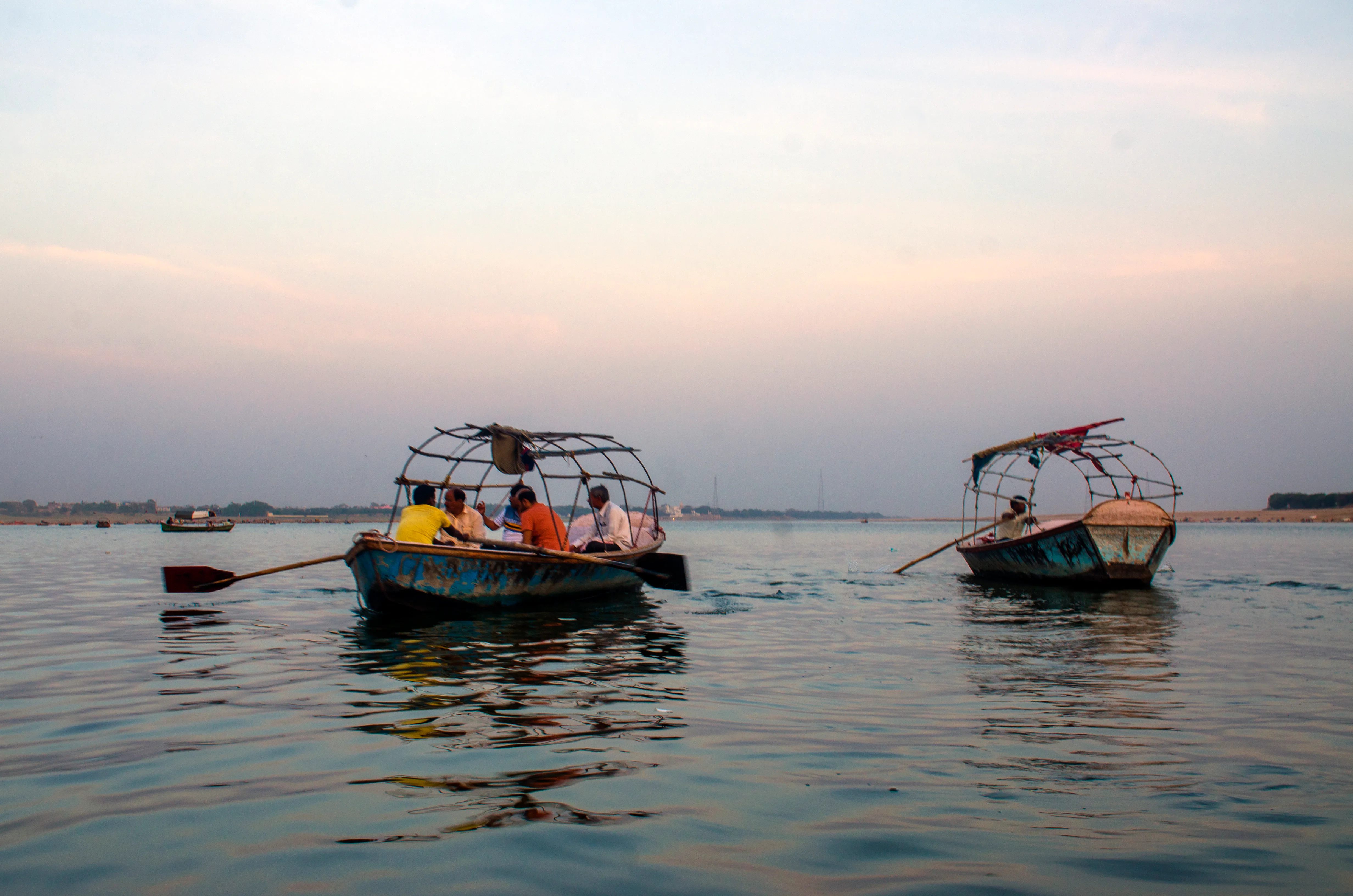 Wooden boats moving across the water at Prayagraj Sangam